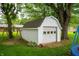 Backyard shed featuring a white exterior, a swing set, and lush greenery for storage and recreation at 1495 E 240 N, Anderson, IN 46012