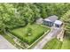 Overhead view of a blue home featuring well-maintained landscaping, a detached garage, and lots of greenery at 1513 Alimingo Dr, Indianapolis, IN 46260