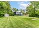 Backyard exterior featuring a two-story home with a large lawn and matching shed at 1513 Alimingo Dr, Indianapolis, IN 46260