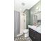 Bathroom with a pebble floor, modern vanity, shower with gray curtain, and a decorative wall color at 1513 Alimingo Dr, Indianapolis, IN 46260