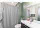 This bathroom features modern vanity, mirror, faucet and grey shower curtain at 1513 Alimingo Dr, Indianapolis, IN 46260