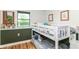 This charming room features wood flooring, a bunkbed and green chair rail at 1513 Alimingo Dr, Indianapolis, IN 46260