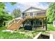 Exterior rear angle showcasing a spacious wooden deck, staircase, and a well-maintained backyard at 1513 Alimingo Dr, Indianapolis, IN 46260