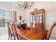 Sunlit dining room with large windows, wooden table, and decorative cabinet with glassware at 1539 Hazy Falls Blvd, Westfield, IN 46074