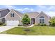 Charming brick home featuring a manicured lawn, two-car garage, and inviting front porch at 1539 Hazy Falls Blvd, Westfield, IN 46074