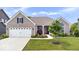 Charming brick home featuring a manicured lawn, two-car garage, and inviting front porch with beautiful landscaping at 1539 Hazy Falls Blvd, Westfield, IN 46074