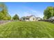Large, well-manicured backyard with lush green lawn and partial wood fence at 16126 Hymera Green, Westfield, IN 46074