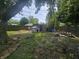 Tree with tire swing and debris in the backyard near a fence line and shed at 1706 Reverend J.T. Menifee St, Anderson, IN 46016