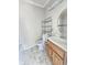Bathroom featuring a toilet, sink with vanity, mirror, and metal storage rack at 1706 Reverend J.T. Menifee St, Anderson, IN 46016