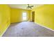 A bright yellow bedroom featuring a window, ceiling fan, carpet, and closet at 1706 Reverend J.T. Menifee St, Anderson, IN 46016