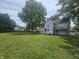 Spacious lawn and mature trees surround this quaint two-story home at 1706 Reverend J.T. Menifee St, Anderson, IN 46016