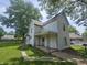 Two-story home with a covered porch and lush, mature trees in the front yard at 1706 Reverend J.T. Menifee St, Anderson, IN 46016