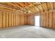 Unfinished garage with a concrete floor, wood framing, and an exit door at 19450 Northwest Dr, Westfield, IN 46074