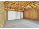 Unfinished garage with a concrete floor, wood framing, and a white garage door at 19450 Northwest Dr, Westfield, IN 46074