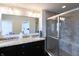 Bathroom featuring double sinks with granite countertops, walk-in shower, and a glimpse of the bedroom at 1972 Rhettsbury St, Carmel, IN 46032