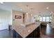 Open kitchen featuring a granite island, dark cabinets, and seamless access to the living area at 1972 Rhettsbury St, Carmel, IN 46032