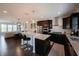 Modern kitchen boasts granite countertops, stainless appliances, and dark wood cabinets, adjacent to a bright living area at 1972 Rhettsbury St, Carmel, IN 46032