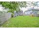 Large backyard with a playhouse, storage shed, and a wooden fence, perfect for outdoor activities at 2235 N Kenwood Ave, Indianapolis, IN 46208