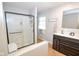 Modern bathroom featuring a glass shower, black vanity with white countertop, and a window at 2235 N Kenwood Ave, Indianapolis, IN 46208