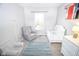 Bright Bedroom features a gray chair, white crib, dresser, and the name 'Theo' displayed on the wall at 2235 N Kenwood Ave, Indianapolis, IN 46208