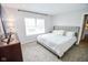 Neutral bedroom features carpeted floors, a window for natural light, upholstered headboard, and a dresser at 2235 N Kenwood Ave, Indianapolis, IN 46208