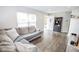 Bright living room with a large window, hardwood floors, and a comfortable sectional sofa at 2235 N Kenwood Ave, Indianapolis, IN 46208