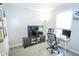 This office has a dark wood tv console and desk with a modern chair and an oversized monitor at 2235 N Kenwood Ave, Indianapolis, IN 46208