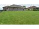 A spacious backyard, bordered by a chain link fence, and a brick house with ample green space at 2330 Oak Dr, Clayton, IN 46118