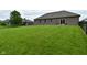 A spacious backyard, offering ample green space, privacy fencing, and brick home exterior at 2330 Oak Dr, Clayton, IN 46118