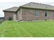 Brick home exterior with a pristine lawn, showing side entry and window details at 2330 Oak Dr, Clayton, IN 46118