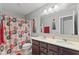 Bathroom featuring double sink vanity with tile backsplash and a floral shower curtain at 2447 Stonehaven Dr, Avon, IN 46123