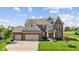 Beautiful two-story brick home featuring a three-car garage and manicured lawn at 2447 Stonehaven Dr, Avon, IN 46123