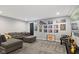 Cozy living room with a sectional sofa, gray carpet, and a large TV; perfect for relaxation at 2447 Stonehaven Dr, Avon, IN 46123
