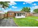 Landscaped backyard featuring a brick house with sunroom and a driveway at 2538 Sickle Rd, Indianapolis, IN 46219