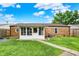 Back exterior view with sunroom, brick siding, lush lawn, and concrete walkway at 2538 Sickle Rd, Indianapolis, IN 46219