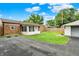 Well-maintained backyard with brick house, sunroom addition, and a paved driveway at 2538 Sickle Rd, Indianapolis, IN 46219