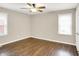 This bedroom features neutral walls, wood floors, two windows, and a ceiling fan at 2538 Sickle Rd, Indianapolis, IN 46219