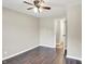 This bedroom has neutral walls, wood floors, a ceiling fan, and an open doorway at 2538 Sickle Rd, Indianapolis, IN 46219