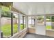 Enclosed sunroom with multiple windows offering backyard views and a door to outside at 2538 Sickle Rd, Indianapolis, IN 46219