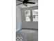 Neutral carpeted bedroom featuring a modern ceiling fan and two windows showcasing the exterior at 2936 Guilford Ave, Indianapolis, IN 46205