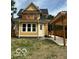 Charming yellow two-story home boasts a balcony, covered walkway, and well-manicured lawn at 2936 Guilford Ave, Indianapolis, IN 46205