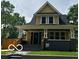 Charming yellow two-story home featuring a covered front porch and manicured lawn at 2936 Guilford Ave, Indianapolis, IN 46205