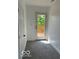 Hallway with neutral carpet, leading to a door opening onto a wooden deck with trees in the background at 2936 Guilford Ave, Indianapolis, IN 46205