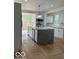 Bright kitchen with gray granite island, stainless steel appliances, and herringbone wood floors at 2936 Guilford Ave, Indianapolis, IN 46205