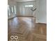 Spacious living room featuring herringbone-pattern wood flooring and an abundance of natural light at 2936 Guilford Ave, Indianapolis, IN 46205
