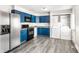 Well-lit kitchen with blue cabinets, modern appliances, and a convenient washer and dryer setup at 315 Schoolhouse Rd, Franklin, IN 46131