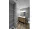 Bathroom with wood-look flooring, granite countertops, storage shelves, and modern vanity at 3327 Brandenburg Blvd, Indianapolis, IN 46239