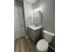 Stylish bathroom features a gray vanity with stone countertop, modern light fixture, and wood-look flooring at 3327 Brandenburg Blvd, Indianapolis, IN 46239