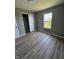Cozy bedroom with wood-look flooring, closet and a bright window overlooking the outdoors at 3327 Brandenburg Blvd, Indianapolis, IN 46239