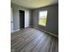 Neutral-colored bedroom features a closet, window and wood-look flooring at 3327 Brandenburg Blvd, Indianapolis, IN 46239